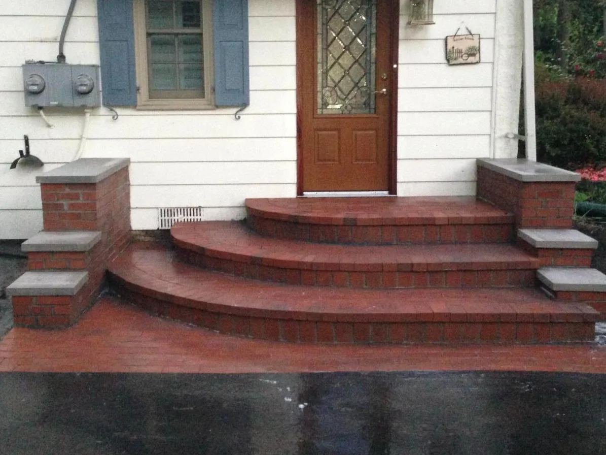 Curved red brick front steps with brick piers and stone caps